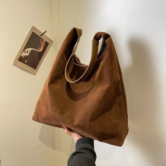 Brown Suede Tote Bag held in hand next to a picture