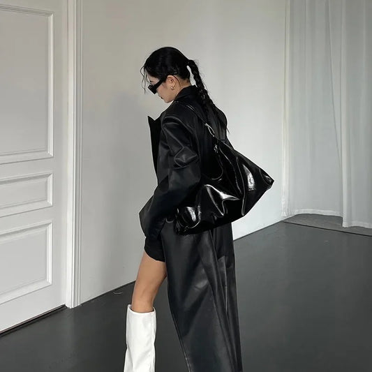 Burgundy Tote Bag in black worn by a woman in a black coat